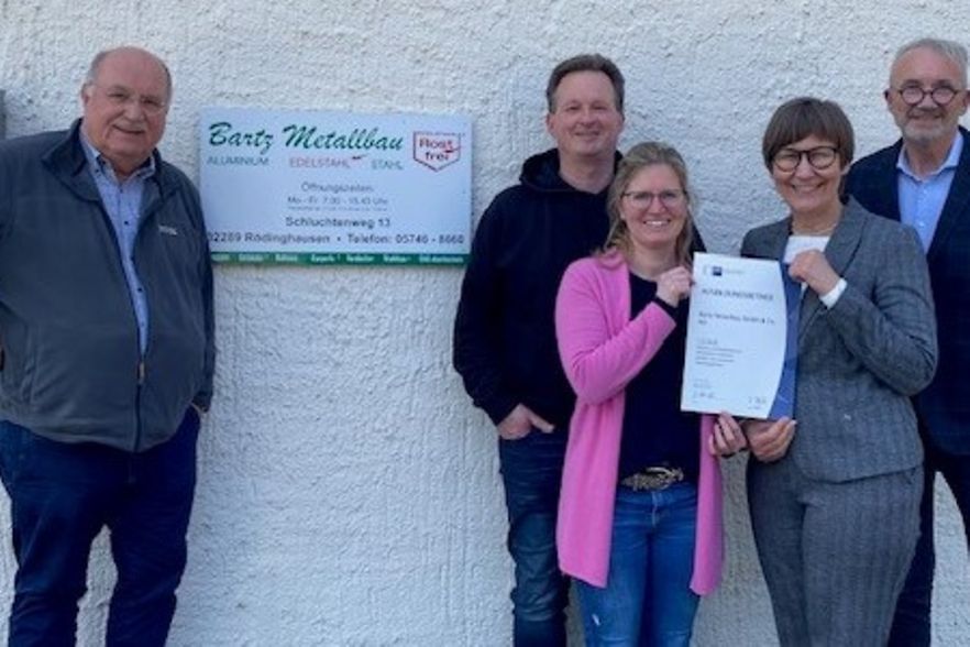 Die Beteiligten stehen vor der Firma "Bartz Metallbau" mit der Urkunde "IHK-anerkannter Ausbildungsbetrieb" in der Hand