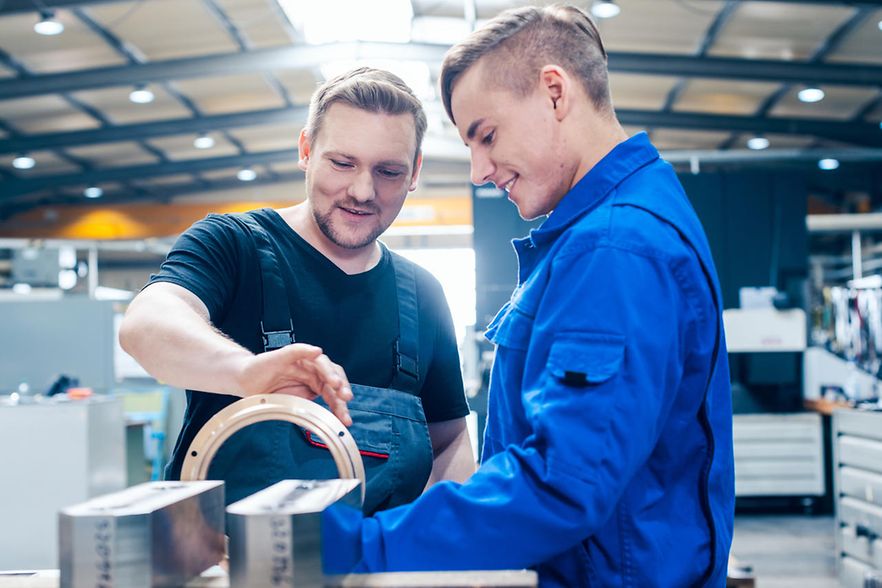 Master discussing a workpiece with his apprentice or trainee