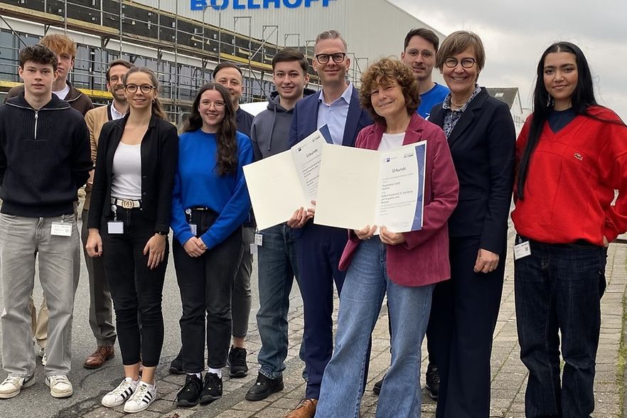 Gruppenfoto mit Urkunden vor dem B&ouml;llhoff-Geb&auml;ude.