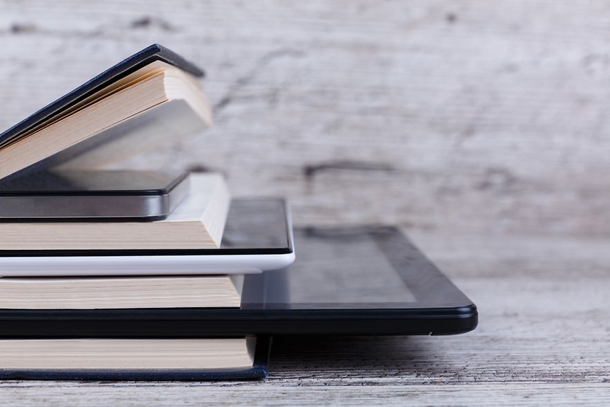 B&uuml;cher und Laptop im Stapel