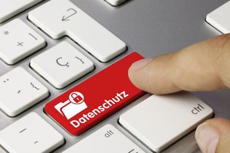 Auf diesem Bild ist eine Tastatur zu sehen. Der Finger einer Person tippt auf die rote Taste "Datenschutz".