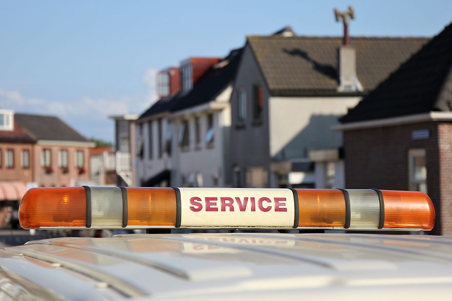 Fahrzeug mit Warnleuchte in Wohnstra&szlig;e.