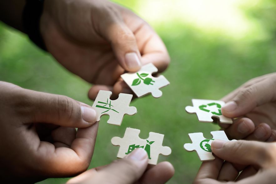 Menschen halten Puzzleteile aneinander