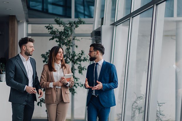 Businesspeople walking and talking in modern office