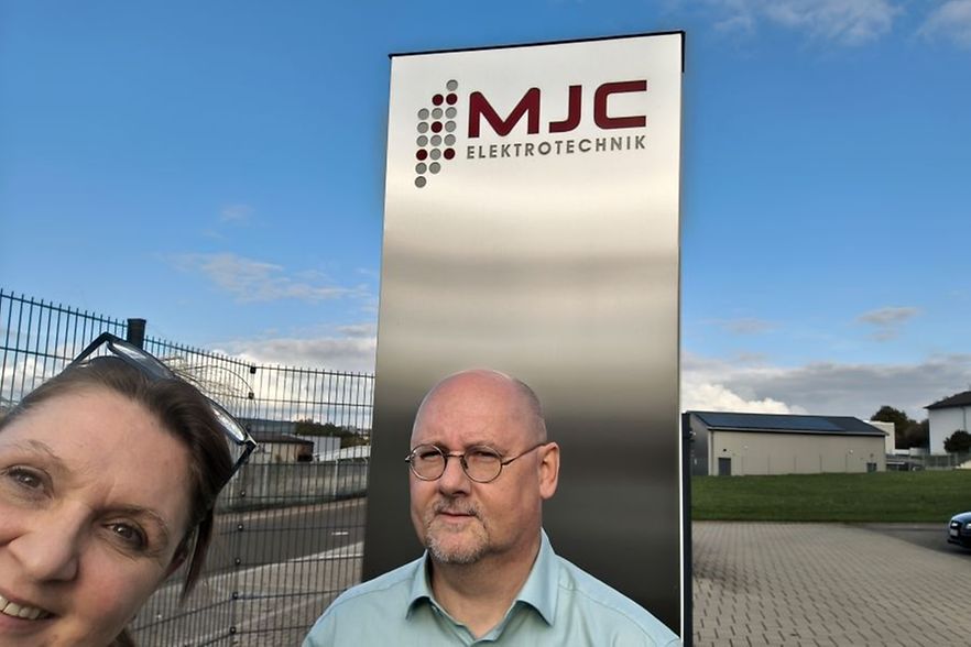 Veronika Pommer gratuliert Martin Conradt von der MJC Elektronik GmbH zum 25j&auml;hrigen Jubil&auml;um vor dem Firmengel&auml;nde