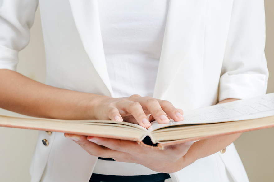 Frau mit aufgeschlagenem Buch in der Hand