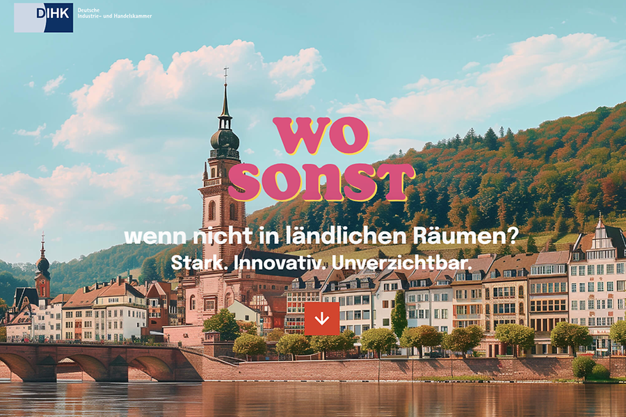 Blick auf einen Fluss mit Brücke und Häusern sowie einer Kirche im Hintergrund