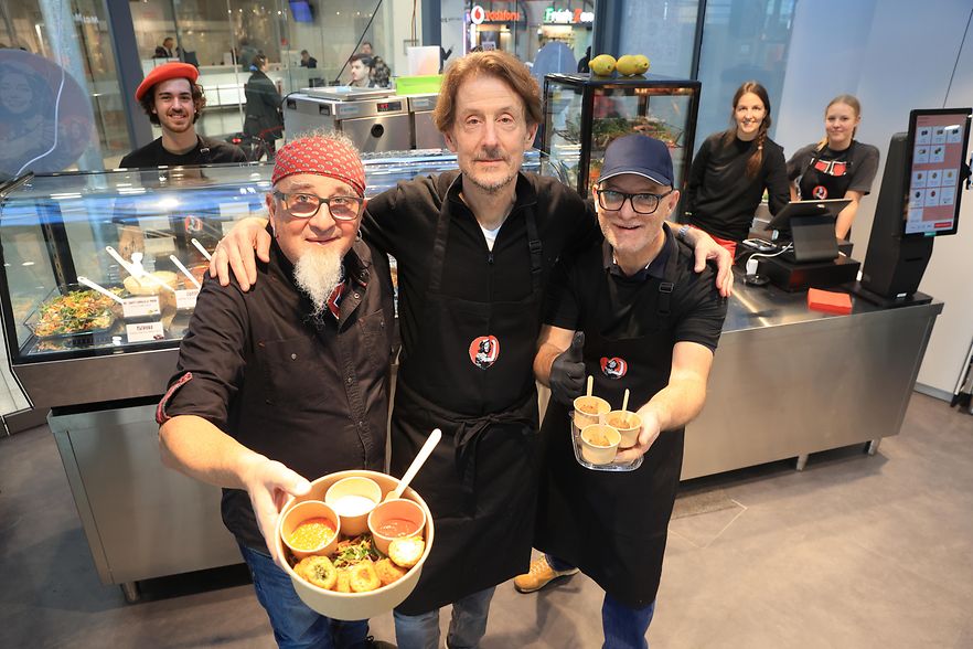 Drei Personen der Stella Moses GmbH halten Snacks in die Kamera