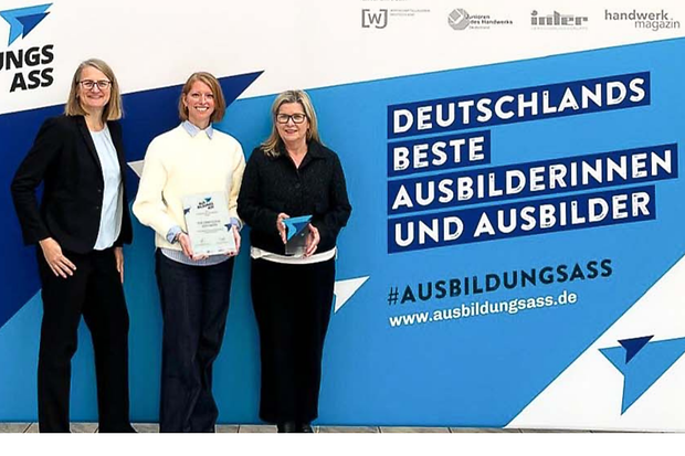 Drei Frauen stehen vor dem Plakat zum Ausbildungs-Ass