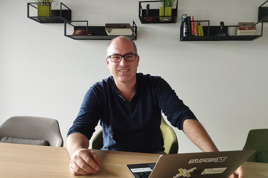 Christian Romeis sitzt vor seinem ge&ouml;ffneten Laptop.