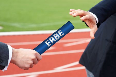 Mann im Anzug &uuml;bergibt Staffelstab mit dem Wort Erbe an einen anderen Mann im Anzug.