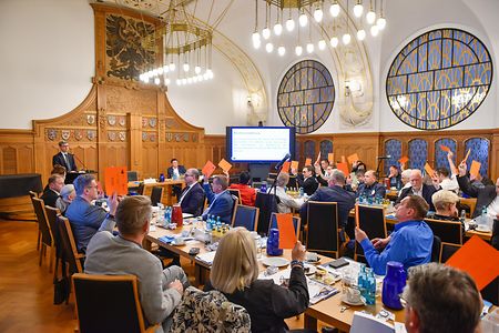 Menschen halten orangene Karten hoch.