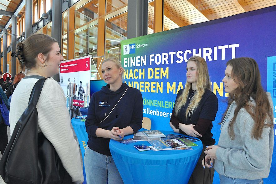Stand auf einer Berufsmesse mit Beratungssituation