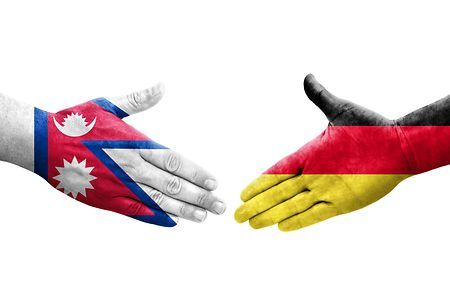 Handshake between Germany and Nepal flags painted on hands, isolated transparent image.