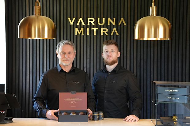 Zwei M&auml;nner pr&auml;sentieren Senf in einer Box.