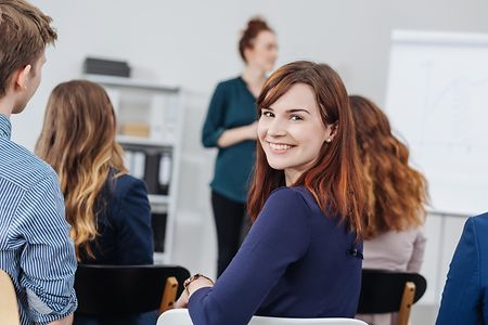 Smiling woman in classroom during seminar