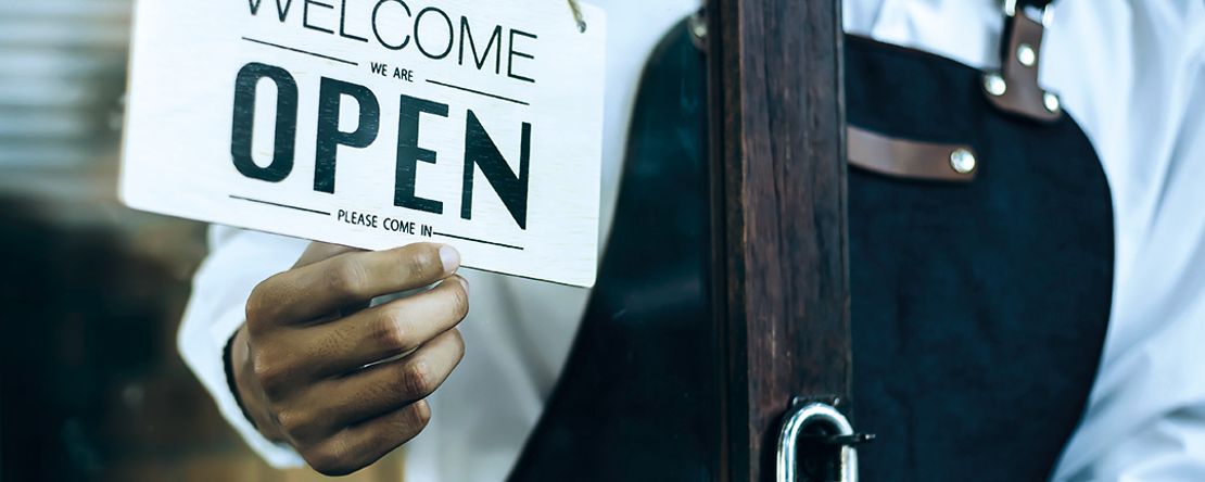 Ein Schild im Schaufenster mit der Aufschrift "OPEN"