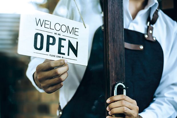 Ein Schild im Schaufenster mit der Aufschrift "OPEN"