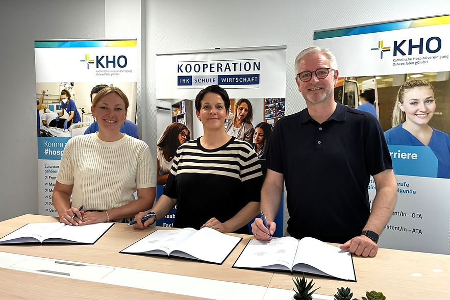 Drei Personen unterzeichnen Kooperationsvereinbarung zwischen KHO und IHK