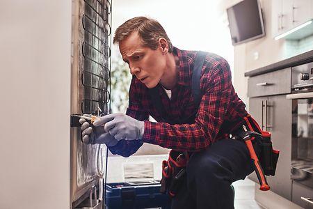 Almost done. Senior male technician checking refrigerator