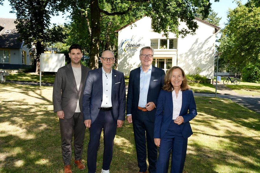Vier Personen vor einem Geb&auml;ude bei einem Unternehmensbesuch