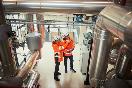 Zwei Ingenieure sehen sich Rohre in einer Fabrik an
