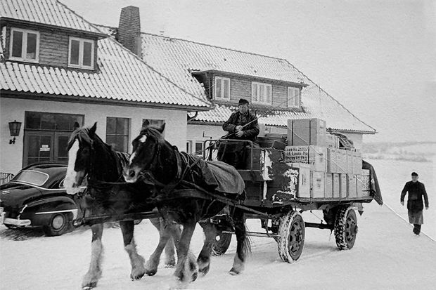 Schwarzwei&szlig;-Foto von einer Kutsche im Schnee vor einer Firma