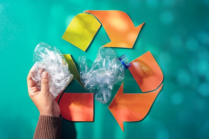 Eine Hand h&auml;lt Plastikfolie neben das Recyclingzeichen