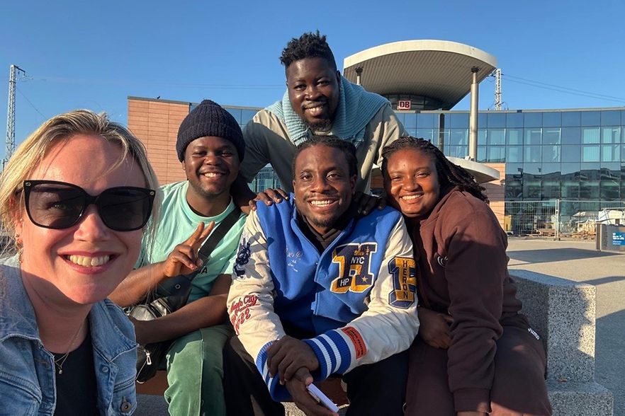Vier afrikanische junge Leute zusammen mit einer Deutschen vor dem Rostocker Hauptbahnhof