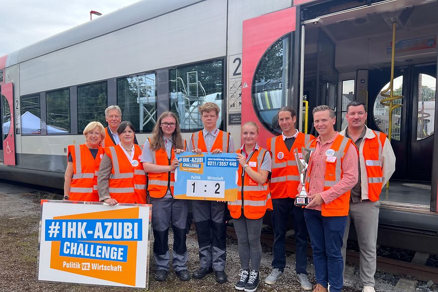 Teilnehmer der Azubi-Challenge stehen vor einer Regiobahn.