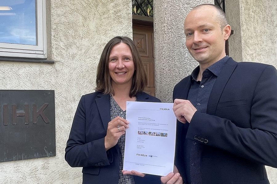 IHK-Referentin Wiebke Eilts und Jens-Peter Gödde vom IFH Köln halten den Innenstadtmonitor in der Hand.