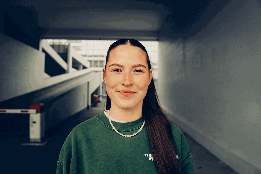 Eine junge Frau l&auml;chelt in die Kamera