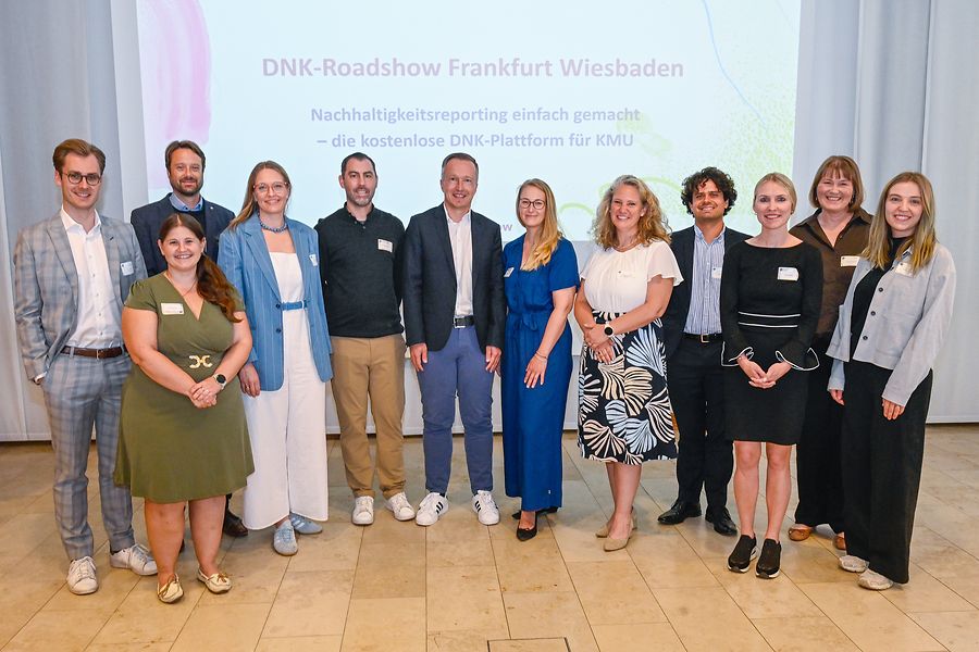 Mehrere Personen vor einer Leinwand, Präasentation mit Titel 