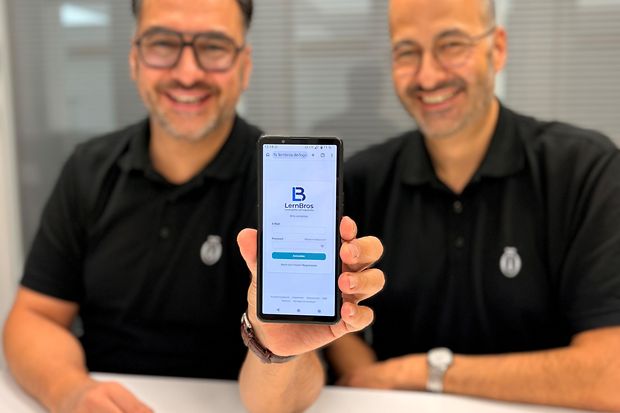 Zwei M&auml;nner halten Handy in die Kamera.