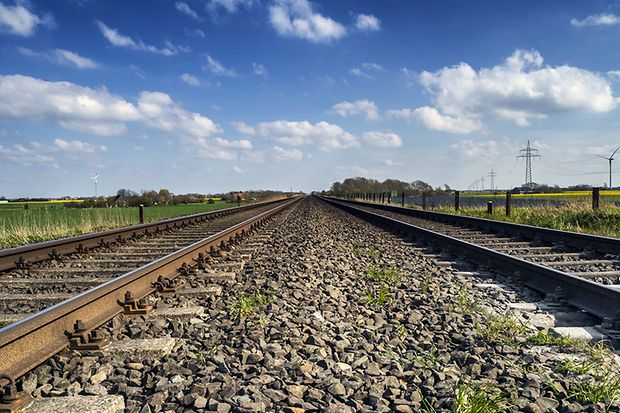 Gerade Eisenbahnstrecke in einer l&auml;ndlichen Landschaft, aufgenommen aus Bodenn&auml;he.