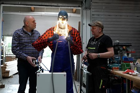 zwei Personen mit Animatronic-Figur in der Hand