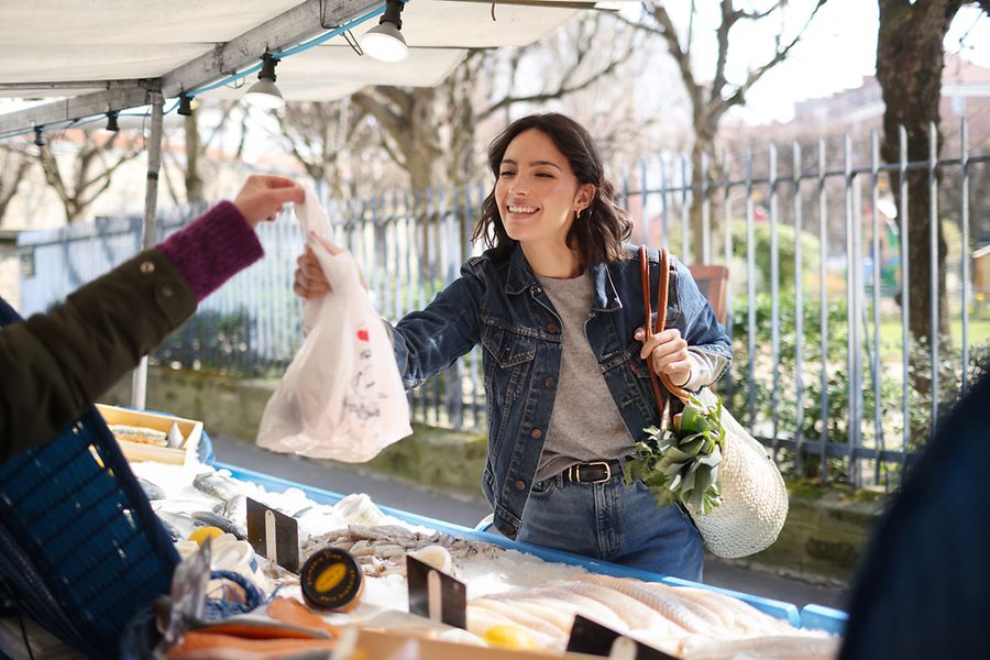 Frau kauft auf einem Fischmarkt ein