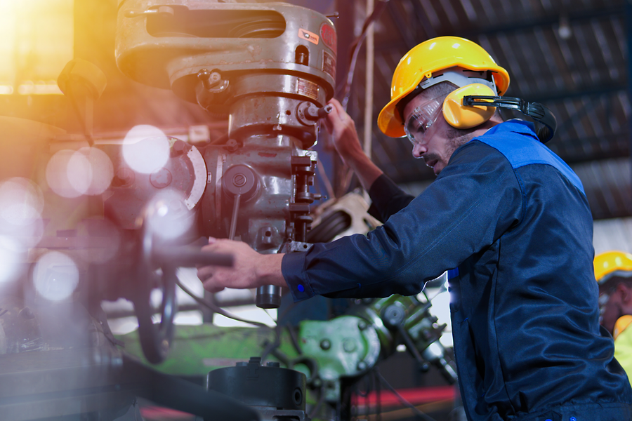 Arbeiter bedient Maschine in einer Werkhalle
