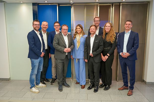 Menschen stehen bei der offiziellen F&ouml;rderbescheid-&Uuml;bergabe nebeneinander.