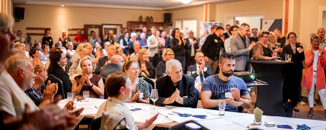 viele Personen sitzend in einem Konferenzraum