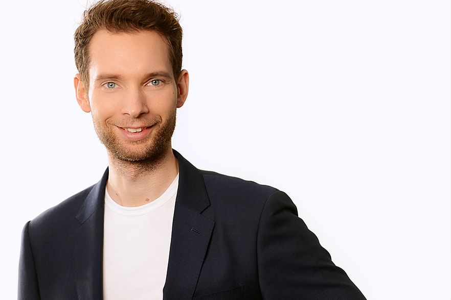 Junger Mann in dunklem Sakko und wei&szlig;em Tshirt
