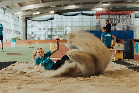 Eine Weitspringerin landet im Sand