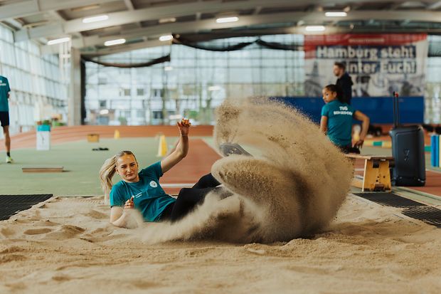 Eine Weitspringerin landet im Sand