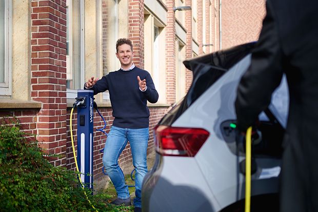 Ein Mann steht einer E-Ladestation