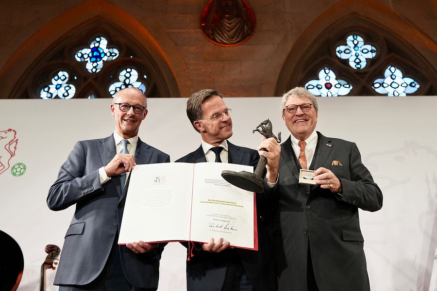 Rutte in Mitte hält Preis, links Merz, rechts Zinkann.