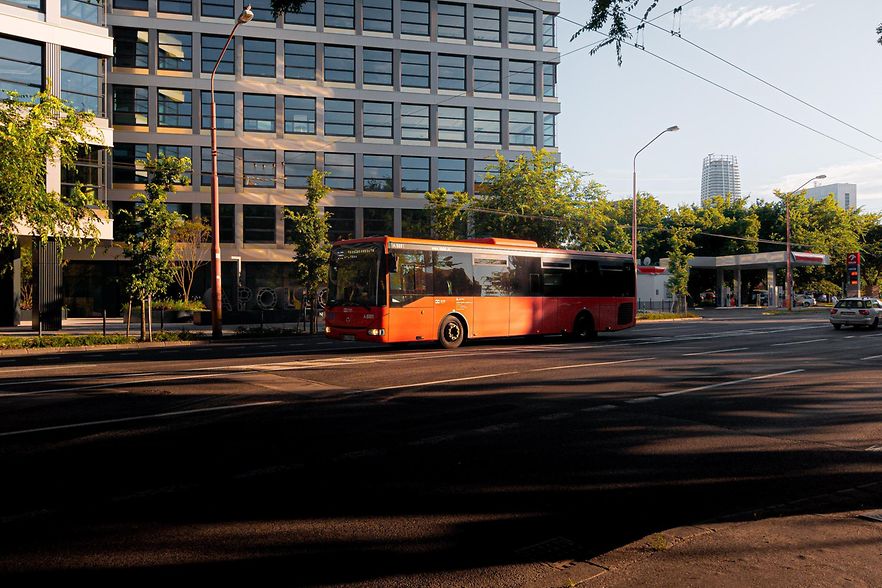 Bus vor Hochhaus auf Stra&szlig;e