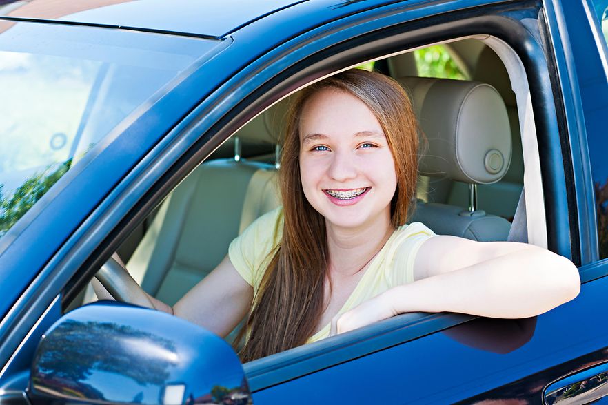 Junge Frau am Steuer eines blauen Autos