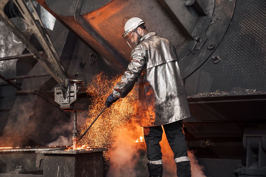 Ein Mann in Sicherheitskleidung am Feuer in der Produktion